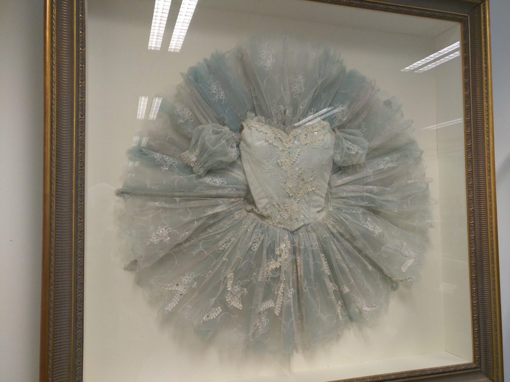 pale blue and white tutu displayed in a glass case